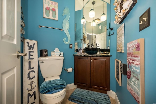 bathroom featuring tile patterned flooring, toilet, and vanity