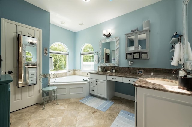 bathroom with a bathing tub, double vanity, and tile patterned floors