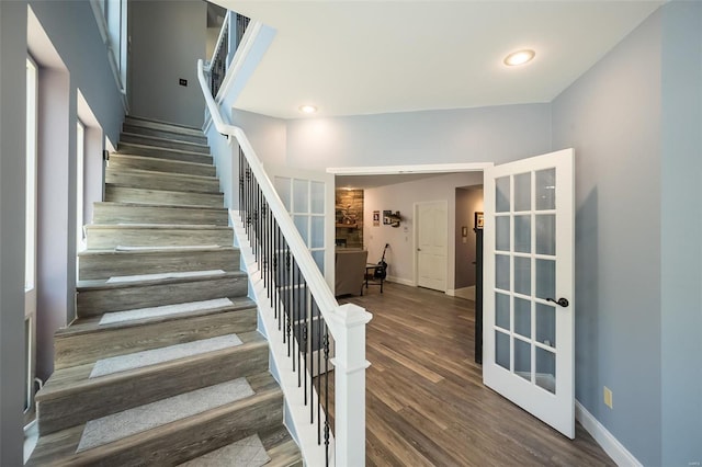 stairway with dark hardwood / wood-style floors and french doors