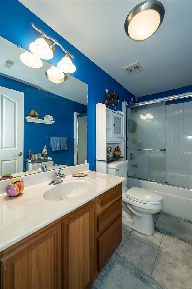 full bathroom featuring combined bath / shower with glass door, tile patterned floors, toilet, and vanity