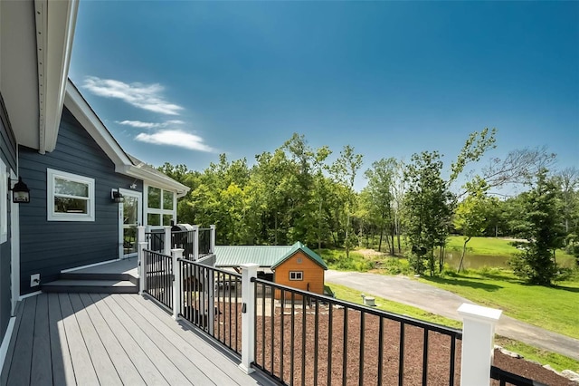 wooden terrace with a yard and an outdoor structure