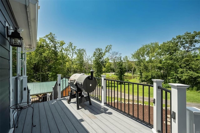 deck featuring area for grilling and a lawn