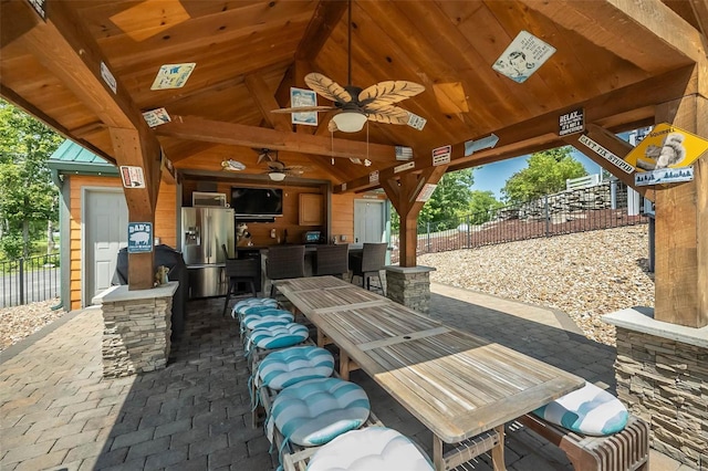 view of patio / terrace with a gazebo, ceiling fan, and a bar