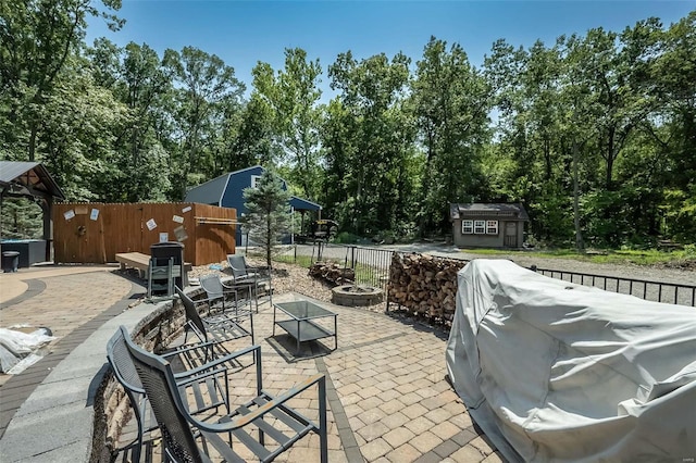 view of patio featuring a shed and an outdoor fire pit