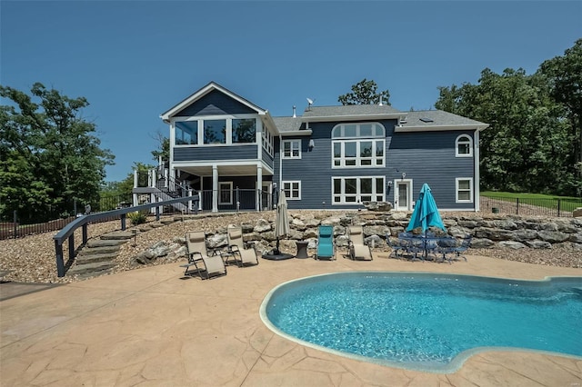 rear view of house with a patio area and a fenced in pool