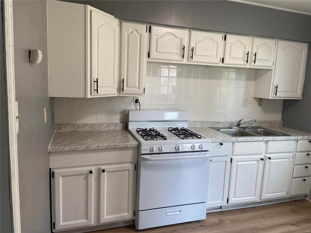 kitchen with sink, white range with gas stovetop, and white cabinets