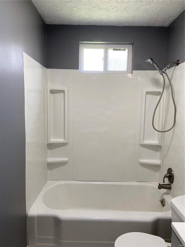 full bathroom with vanity, toilet, bathing tub / shower combination, and a textured ceiling