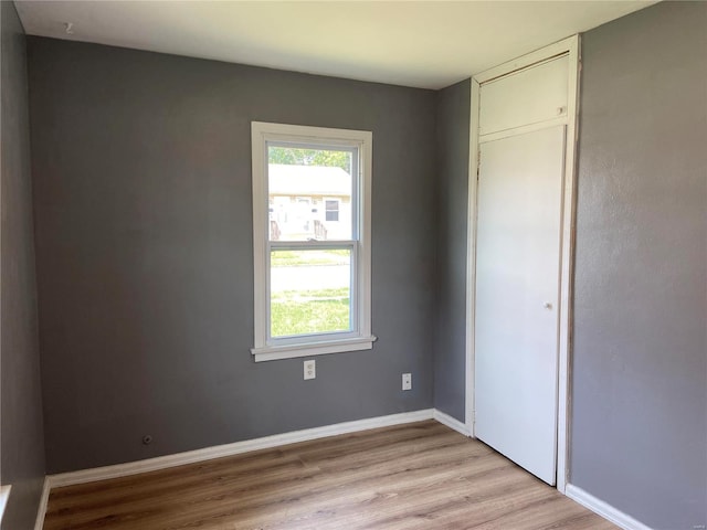 unfurnished bedroom with light hardwood / wood-style floors and a closet