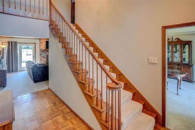 stairs with a towering ceiling and light colored carpet