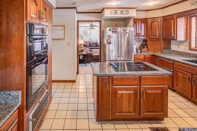 kitchen with black double oven, electric cooktop, a center island, high end refrigerator, and light tile patterned floors