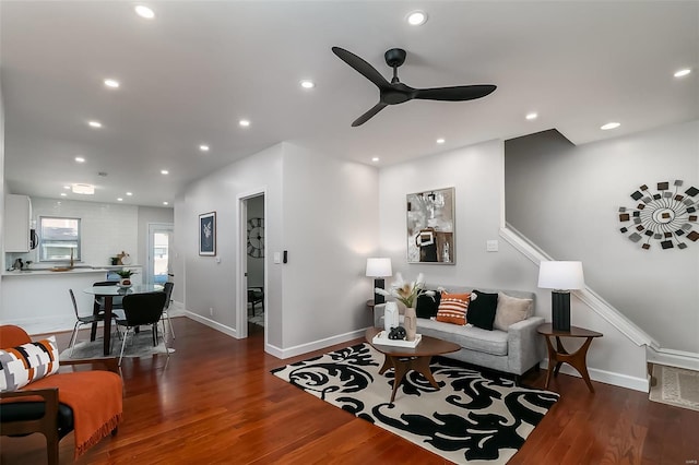 living room with ceiling fan and dark hardwood / wood-style flooring