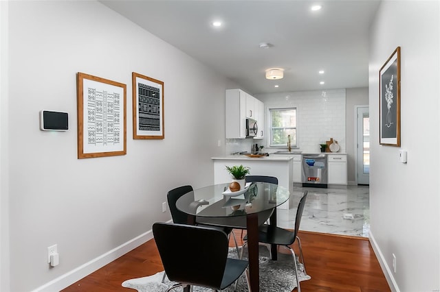 dining room featuring sink and dark wood-type flooring