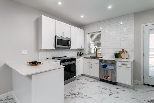 kitchen featuring sink, kitchen peninsula, white cabinetry, stainless steel appliances, and decorative backsplash