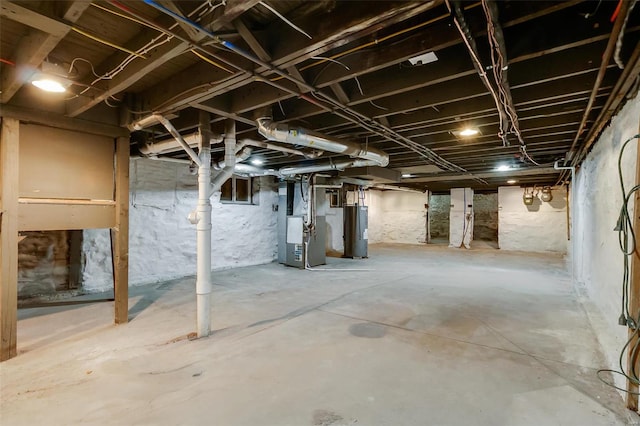 basement featuring water heater and heating unit