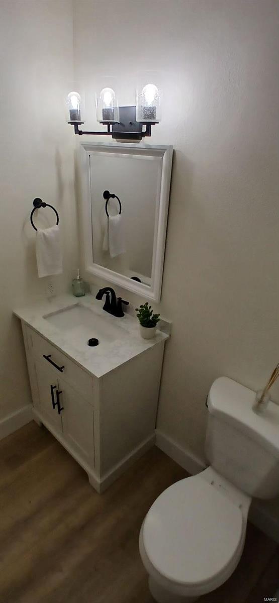 bathroom featuring vanity, wood-type flooring, and toilet