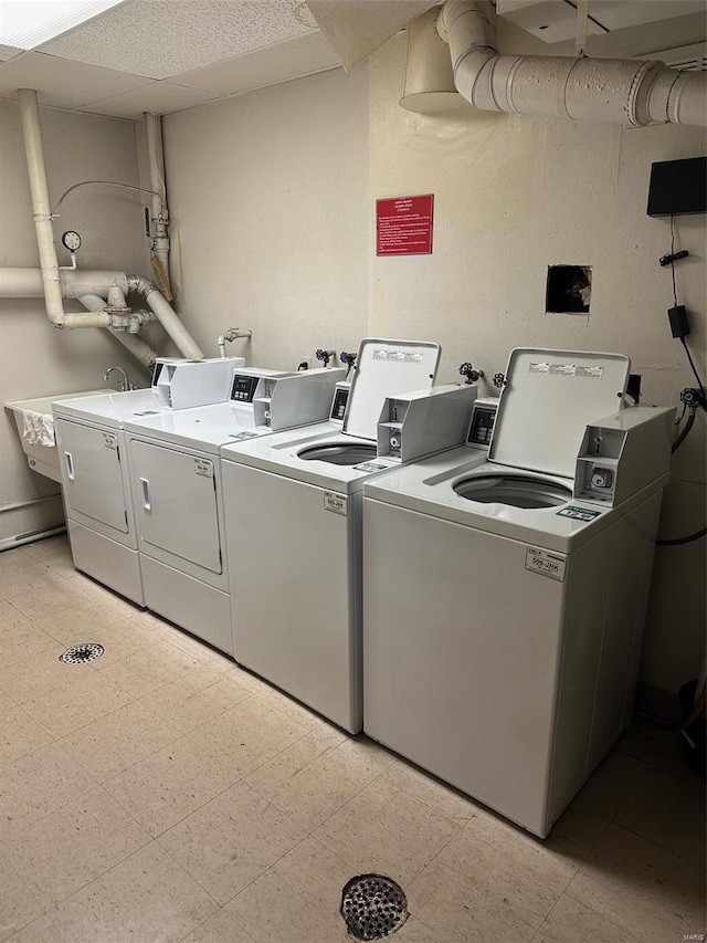 laundry area with separate washer and dryer, sink, and light tile patterned floors