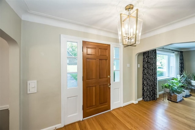 foyer featuring a notable chandelier, crown molding, and hardwood / wood-style floors