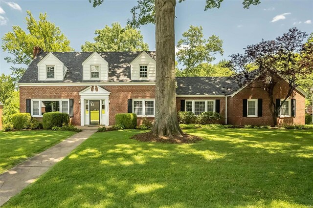 cape cod-style house featuring a front yard