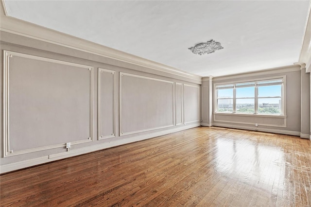 empty room featuring ornamental molding and light hardwood / wood-style floors