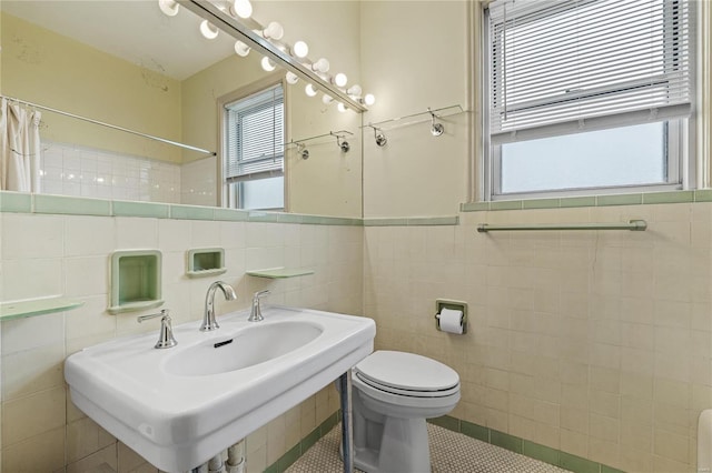 bathroom featuring tile walls, sink, and a wealth of natural light