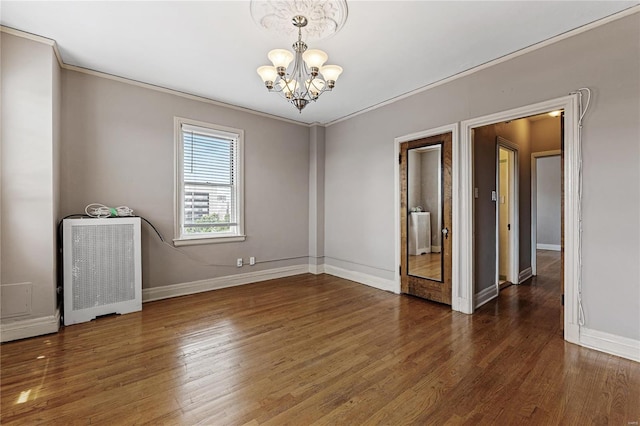 empty room featuring an inviting chandelier, ornamental molding, dark hardwood / wood-style floors, and radiator heating unit