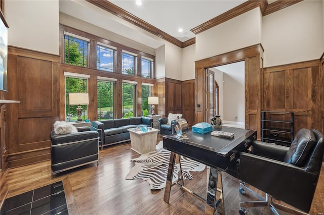 office space featuring a high ceiling, ornamental molding, and hardwood / wood-style floors