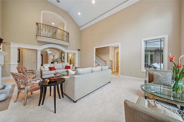 living room featuring light colored carpet, ornate columns, and high vaulted ceiling