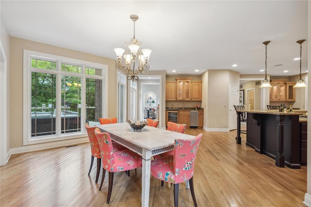 dining room featuring light hardwood / wood-style floors, a chandelier, and wine cooler