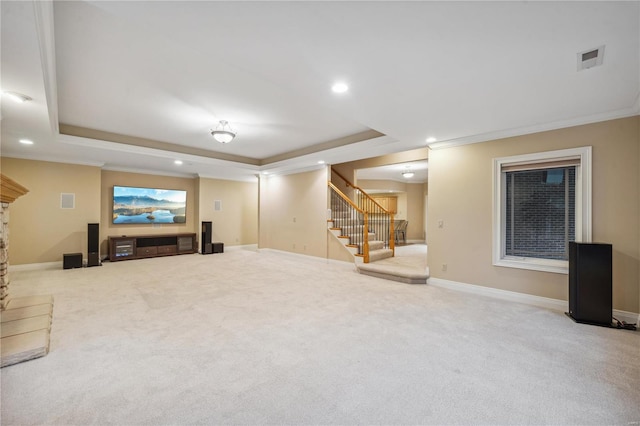 carpeted living room with a tray ceiling and ornamental molding