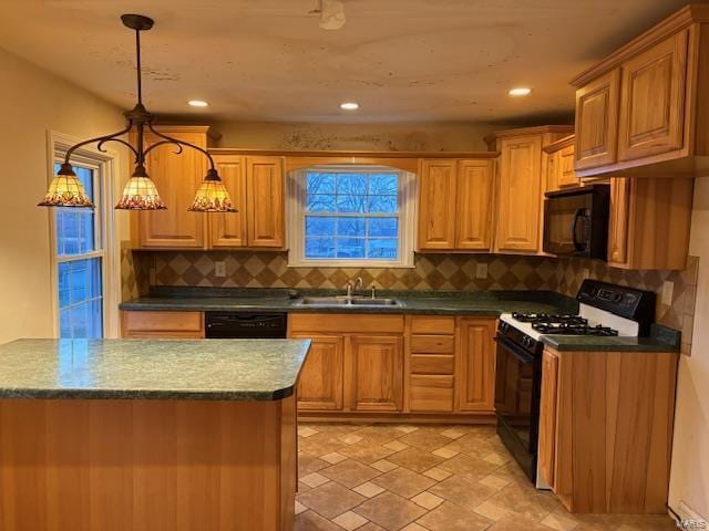 kitchen with pendant lighting, sink, tasteful backsplash, and black appliances