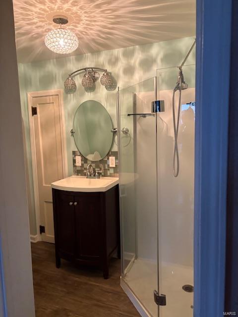 bathroom featuring a shower with shower door, wood-type flooring, and vanity