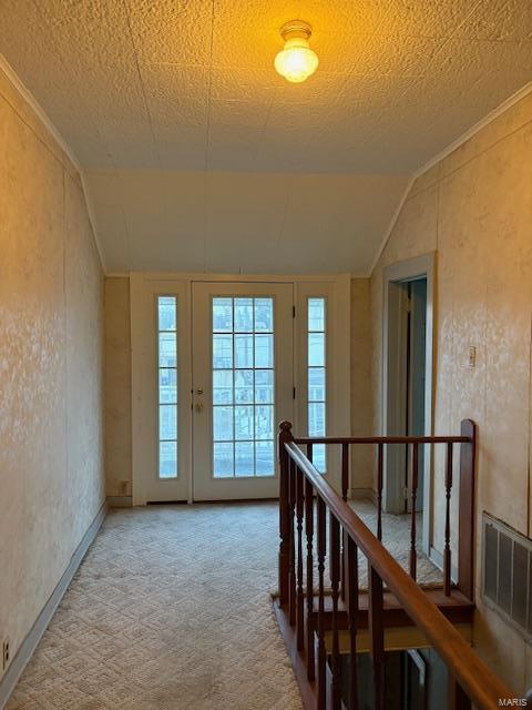 corridor with carpet, a textured ceiling, and lofted ceiling