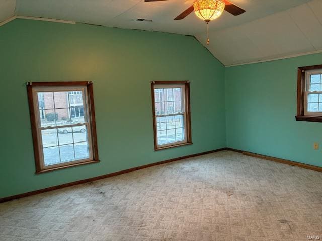 empty room featuring ceiling fan, light colored carpet, and vaulted ceiling