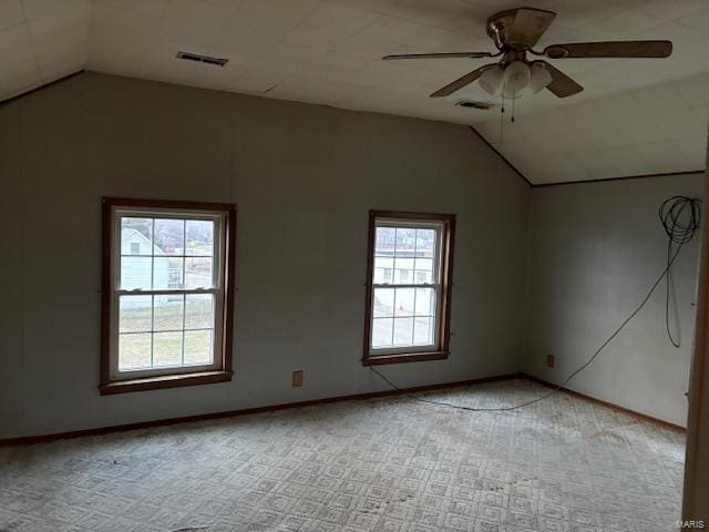 carpeted spare room with plenty of natural light, lofted ceiling, and ceiling fan