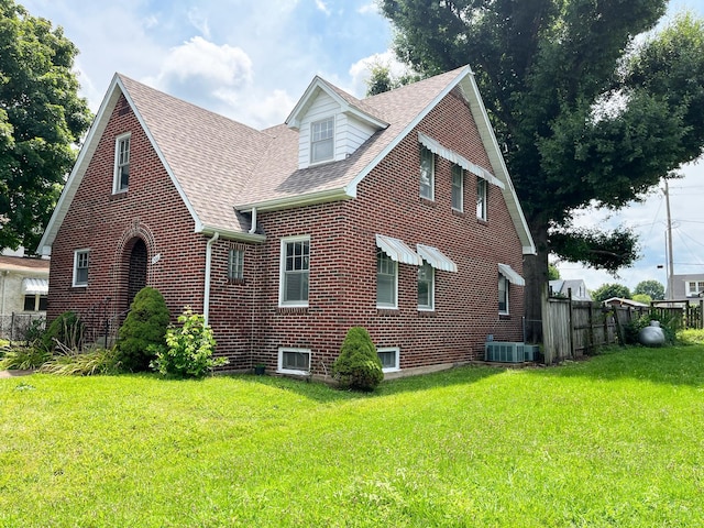 view of front facade featuring central AC unit and a front yard