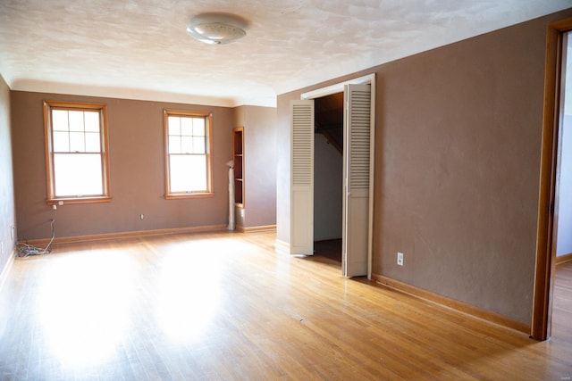 unfurnished bedroom with a textured ceiling and light hardwood / wood-style floors