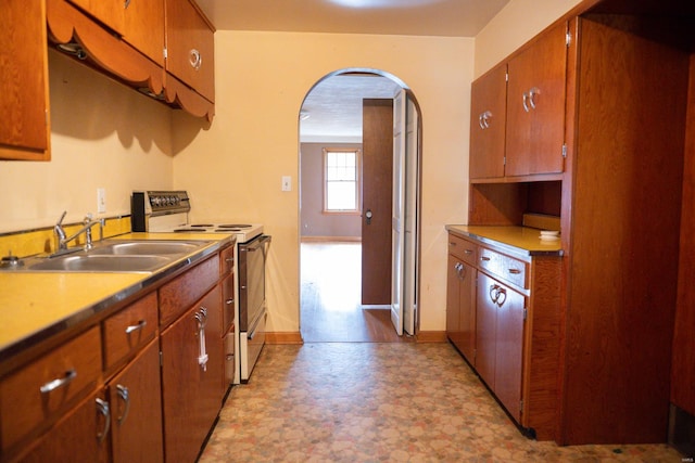 kitchen featuring sink, stainless steel range with electric stovetop, and light wood-type flooring