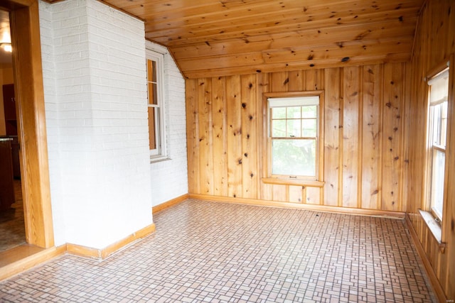 spare room with wood walls, vaulted ceiling, and wooden ceiling