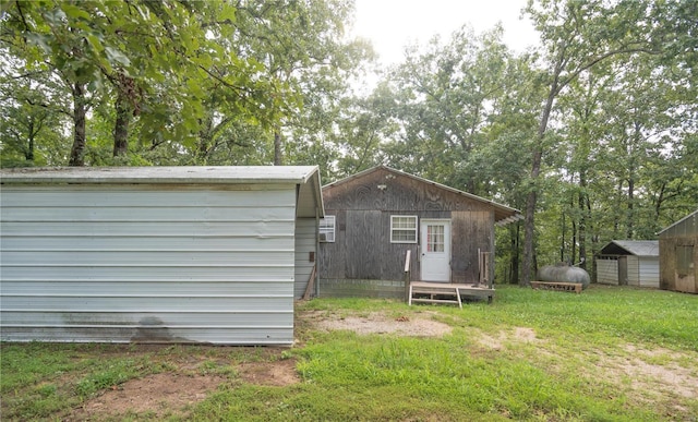 back of house featuring an outbuilding and a yard