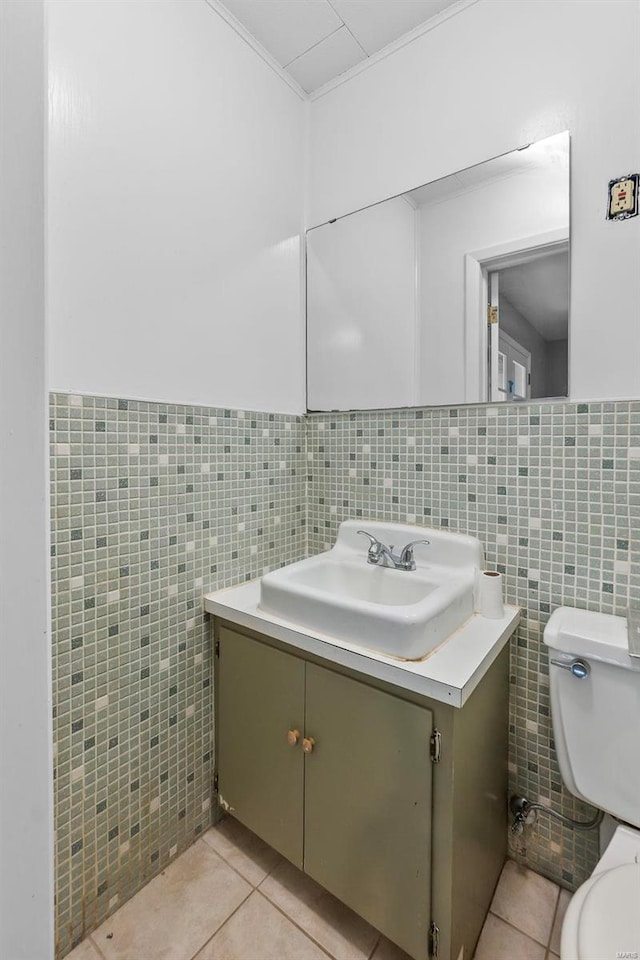 bathroom with vanity, tile patterned floors, toilet, and tile walls