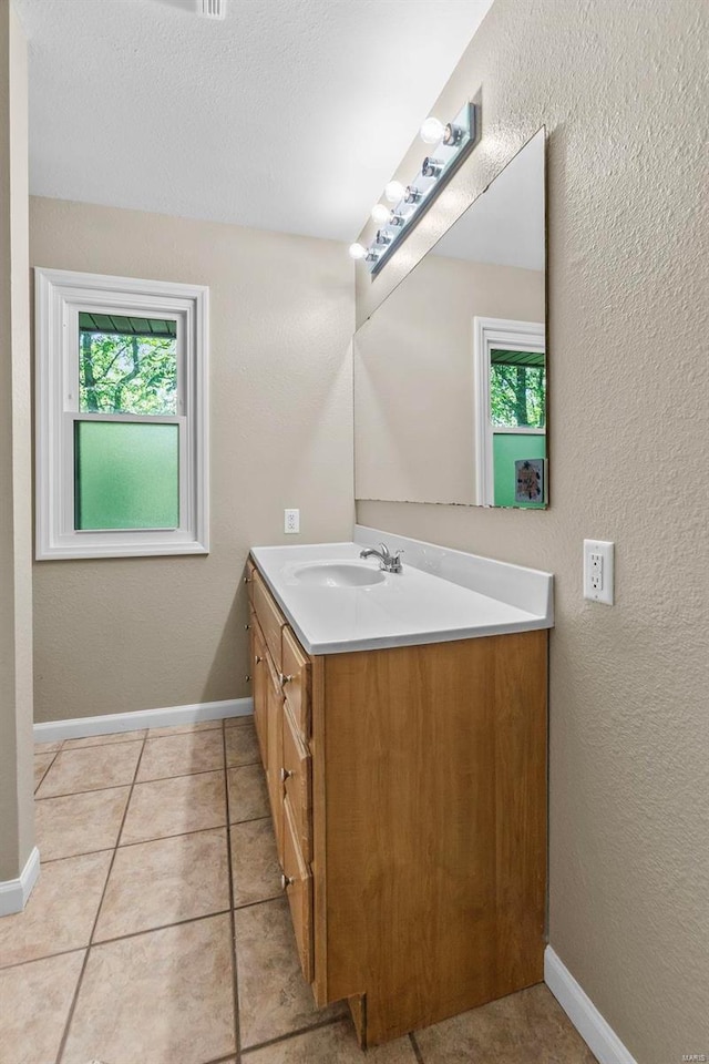 bathroom featuring vanity, a textured ceiling, tile patterned flooring, and plenty of natural light