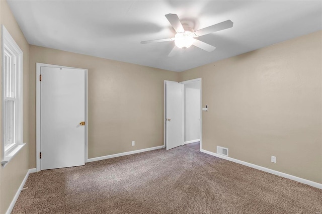 carpeted spare room featuring ceiling fan