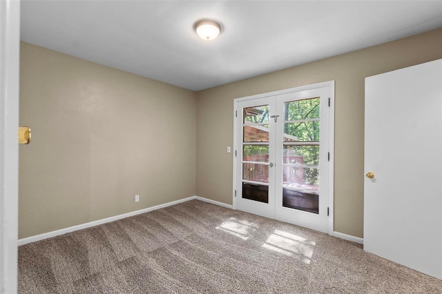 carpeted spare room featuring french doors