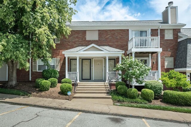 view of front of house featuring covered porch and a balcony