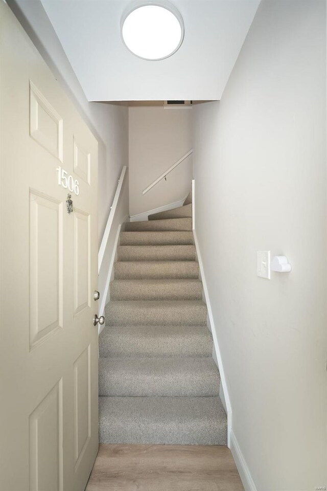 stairs featuring light wood-type flooring