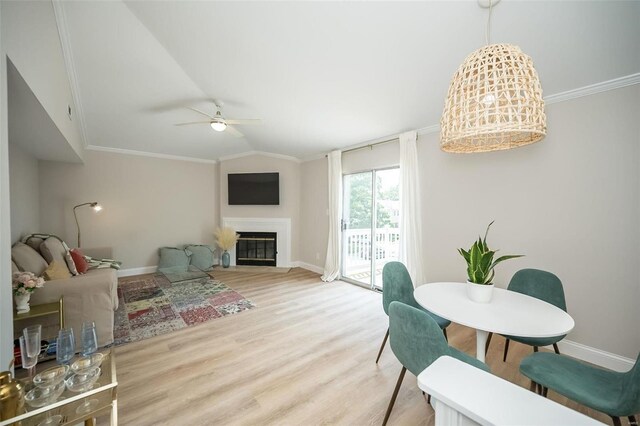 living room with crown molding, light wood-type flooring, ceiling fan, and lofted ceiling