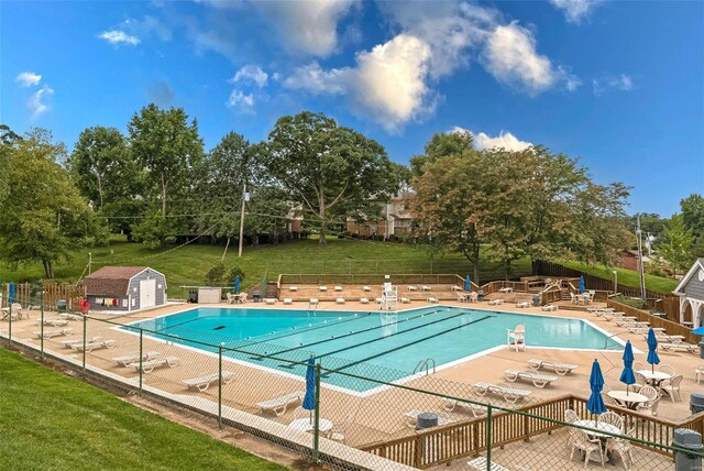 view of pool with a patio area and a lawn