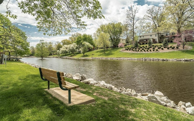 view of home's community featuring a lawn and a water view