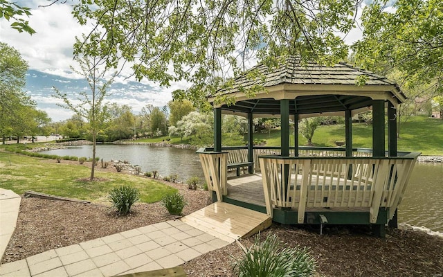 dock area featuring a gazebo, a deck with water view, and a lawn