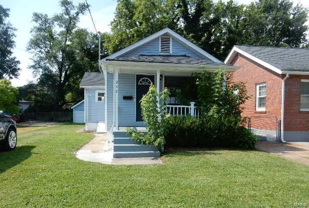 bungalow with covered porch and a front lawn